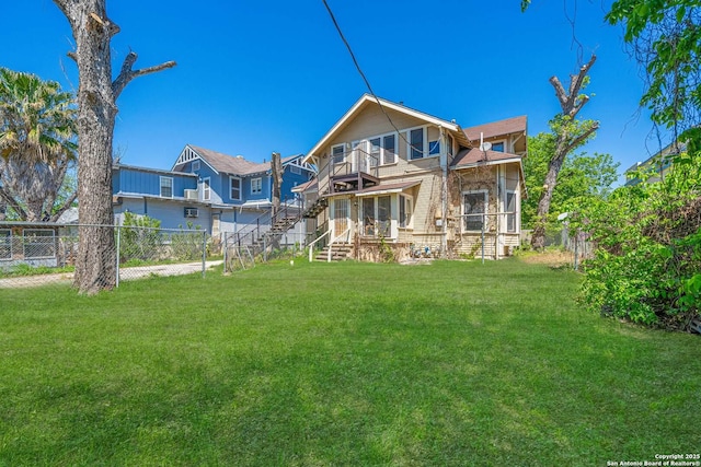 back of property with a yard, a fenced backyard, and a balcony
