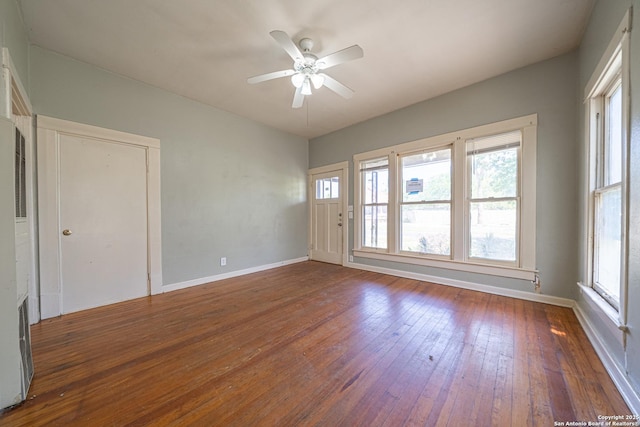 unfurnished room with baseboards, ceiling fan, wood-type flooring, and plenty of natural light