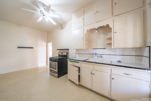 kitchen featuring tile countertops, open shelves, a sink, electric stove, and decorative backsplash