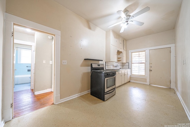 kitchen with a healthy amount of sunlight, gas stove, baseboards, and white cabinetry