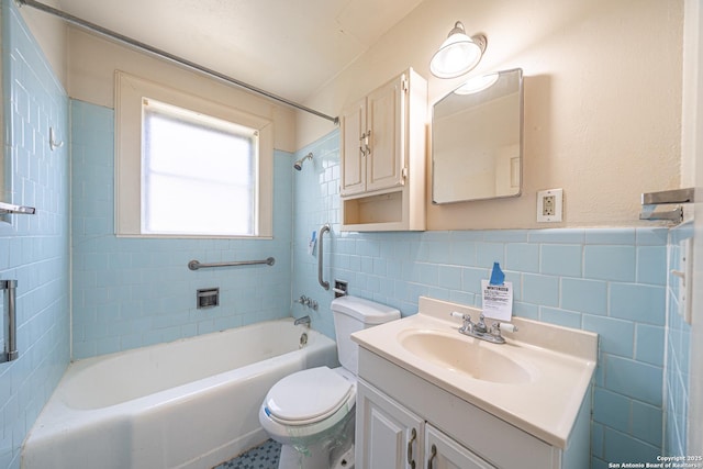 bathroom featuring shower / washtub combination, vanity, a wainscoted wall, toilet, and tile walls