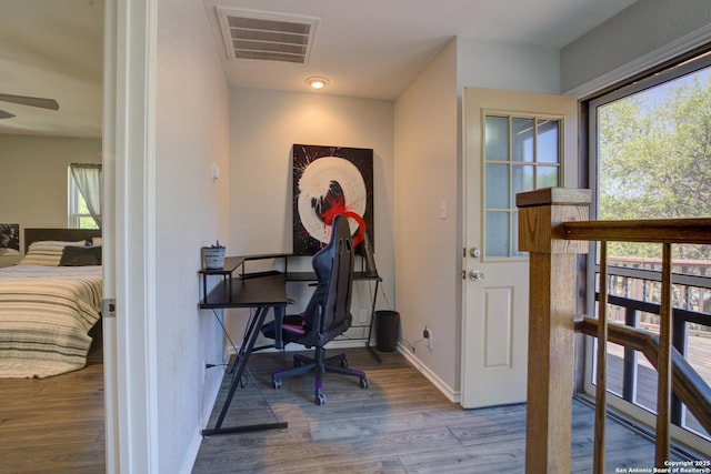 office space featuring wood finished floors, baseboards, visible vents, and a wealth of natural light