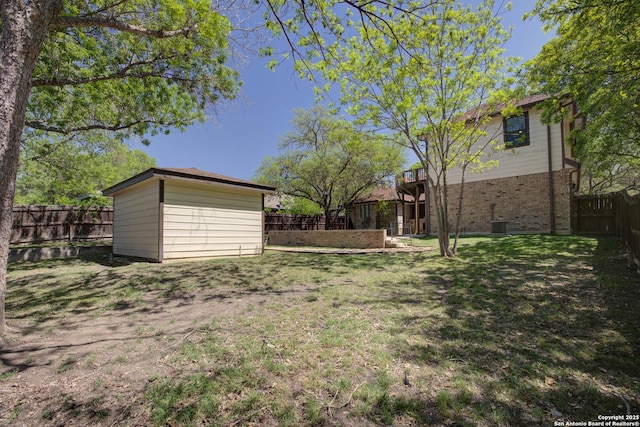 view of yard with a storage shed, a fenced backyard, an outdoor structure, and cooling unit