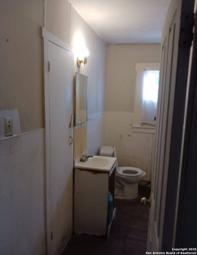 1915 Pasadena St, San Antonio, TX 78201 - bathroom featuring toilet, tile walls, vanity, and a wainscoted wall