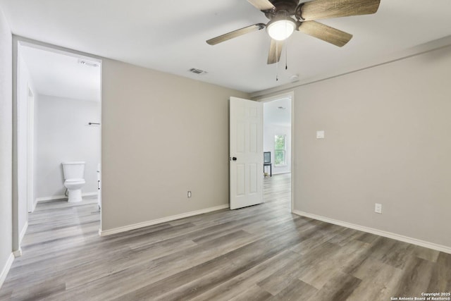 1360 Essex, San Antonio, TX 78210 - unfurnished bedroom with visible vents, baseboards, a ceiling fan, ensuite bath, and wood finished floors