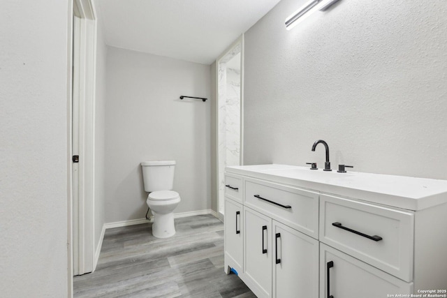 1360 Essex, San Antonio, TX 78210 - bathroom featuring vanity, baseboards, toilet, and wood finished floors