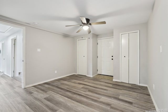 1360 Essex, San Antonio, TX 78210 - unfurnished bedroom with baseboards, attic access, multiple closets, ceiling fan, and wood finished floors