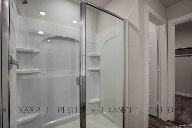 4731 Sahara Vlys, San Antonio, TX 78222 - bathroom with a shower stall, recessed lighting, a spacious closet, and wood finished floors