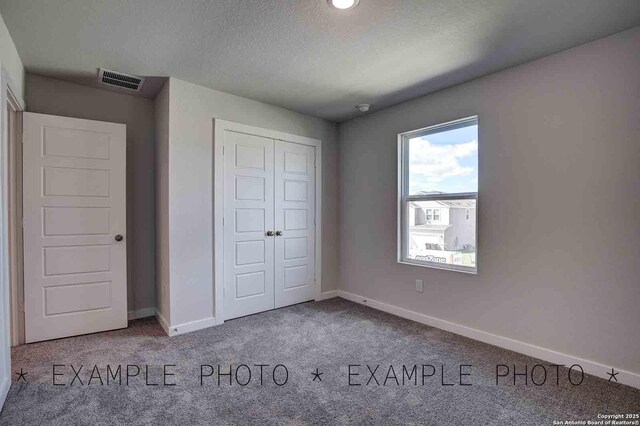 4731 Sahara Vlys, San Antonio, TX 78222 - unfurnished bedroom featuring a closet, baseboards, carpet flooring, a textured ceiling, and visible vents