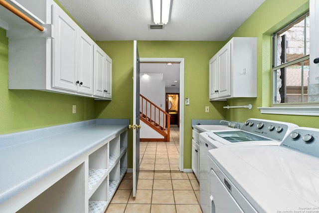 laundry area featuring visible vents, a sink, light tile patterned floors, independent washer and dryer, and cabinet space