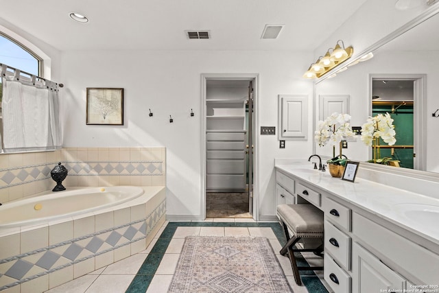 bathroom featuring tile patterned floors, visible vents, a sink, and a walk in closet