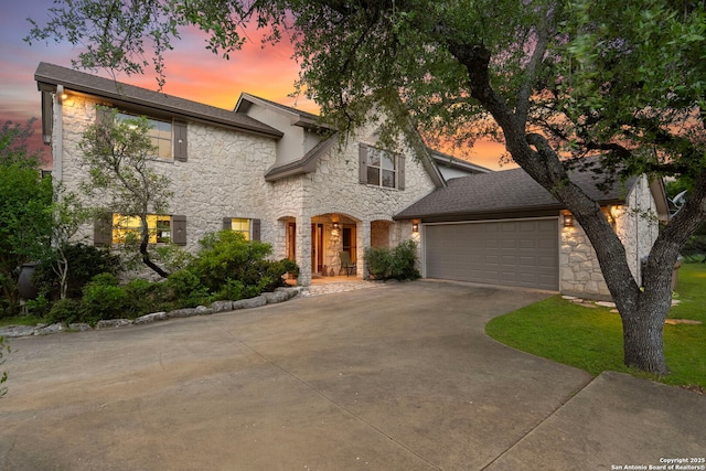 view of front facade featuring stone siding, a garage, and concrete driveway