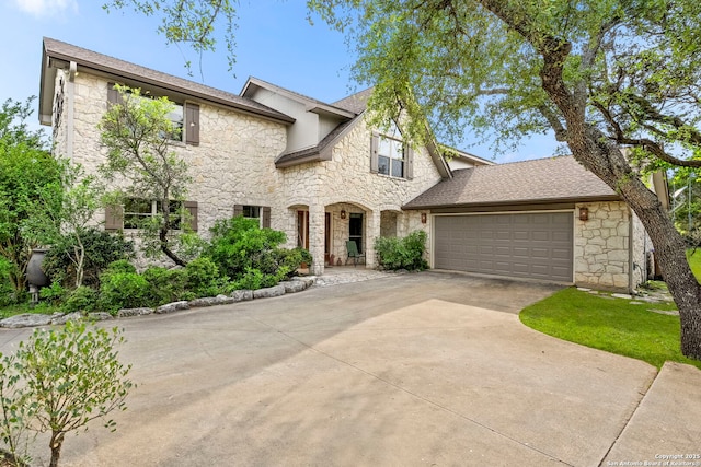 view of front of property with stone siding, an attached garage, and concrete driveway