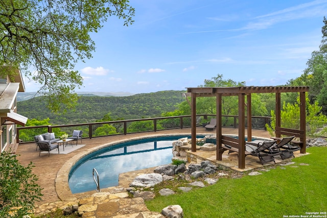 view of pool featuring outdoor lounge area, a fenced in pool, and a deck with mountain view