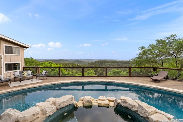 view of pool with a pool with connected hot tub and a deck