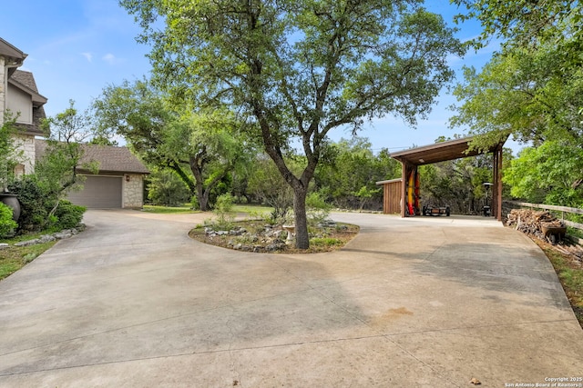 exterior space featuring stone siding, curved driveway, and a garage
