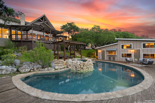 pool at dusk featuring an outdoor pool, an outdoor hangout area, and a deck