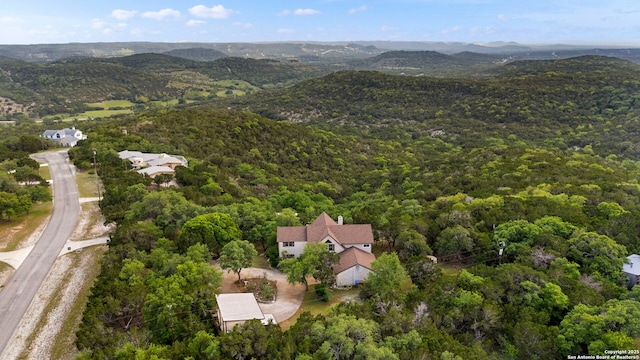 birds eye view of property featuring a mountain view and a wooded view