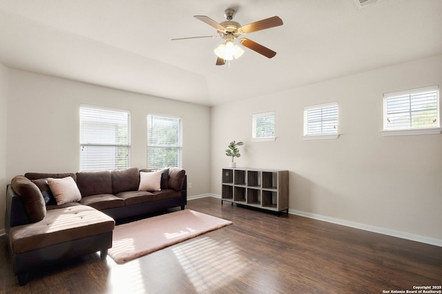 living room with a wealth of natural light, baseboards, and wood finished floors