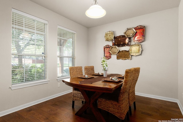 dining room with dark wood-type flooring and baseboards