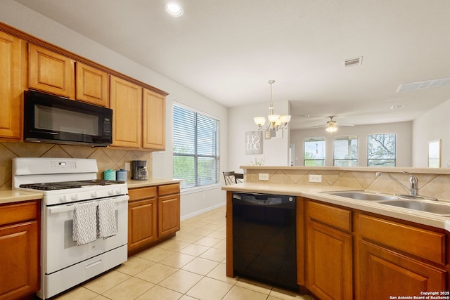 kitchen with a sink, visible vents, light countertops, and black appliances