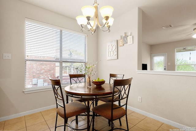dining room with ceiling fan with notable chandelier, light tile patterned floors, baseboards, and visible vents