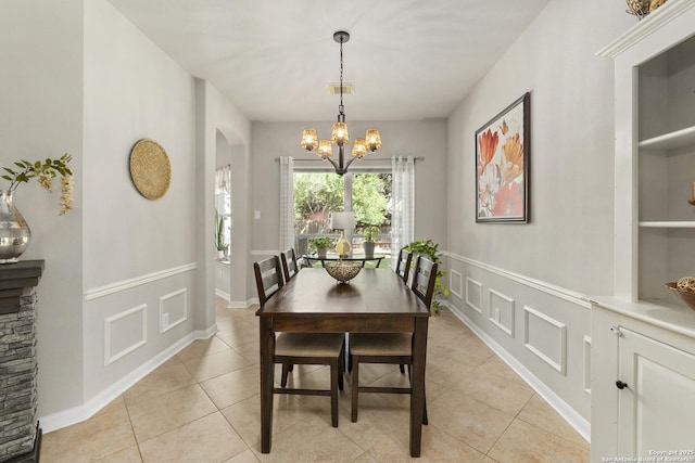 4 Andover Creek Dr, San Antonio, TX 78254 - dining room with a chandelier, light tile patterned floors, arched walkways, and a wainscoted wall