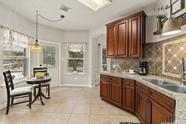 4 Andover Creek Dr, San Antonio, TX 78254 - kitchen featuring a sink, tasteful backsplash, arched walkways, pendant lighting, and light tile patterned floors