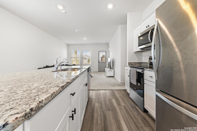 7415 Cheetah Pass, San Antonio, TX 78253 - kitchen with a sink, appliances with stainless steel finishes, dark wood-style floors, white cabinetry, and light stone counters