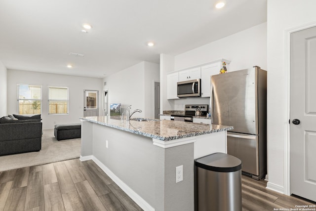 7415 Cheetah Pass, San Antonio, TX 78253 - kitchen featuring light stone counters, an island with sink, white cabinetry, stainless steel appliances, and a sink