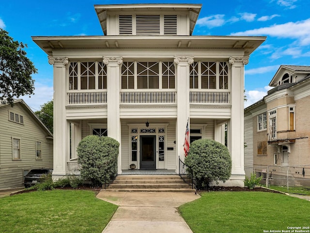view of front of home featuring a porch, a balcony, and a front yard