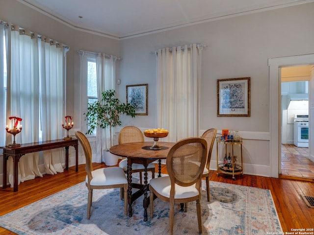 dining area featuring crown molding, wood finished floors, and visible vents