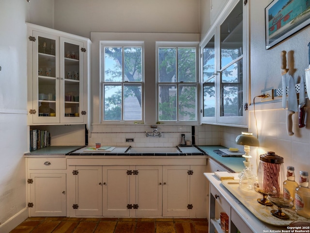 kitchen featuring glass insert cabinets, tile counters, tasteful backsplash, and white cabinets