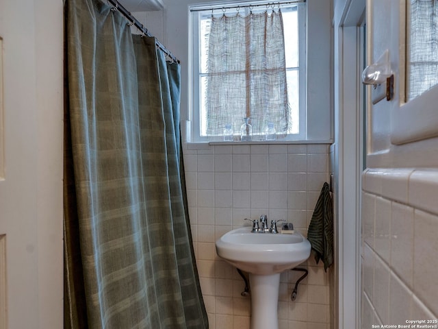 bathroom with tile walls and a shower with shower curtain