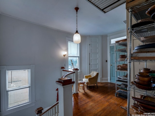 interior space with crown molding, baseboards, hardwood / wood-style floors, and an upstairs landing