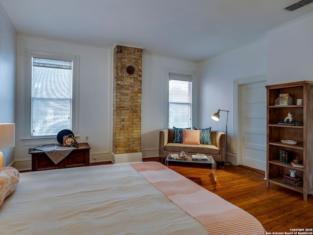 bedroom featuring visible vents and wood finished floors