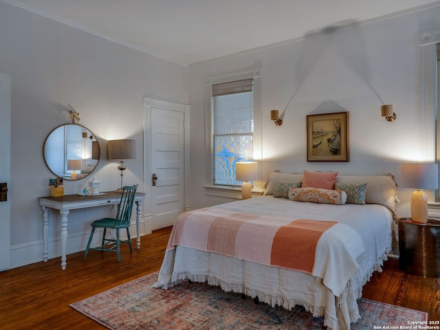 bedroom featuring ornamental molding and wood finished floors
