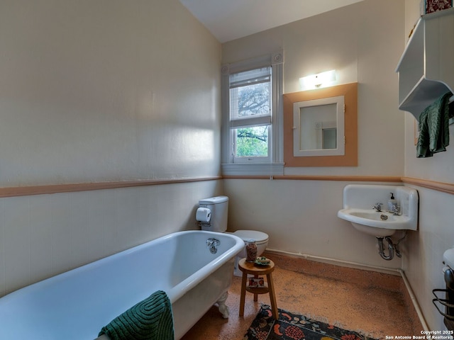 full bathroom with toilet and a freestanding tub