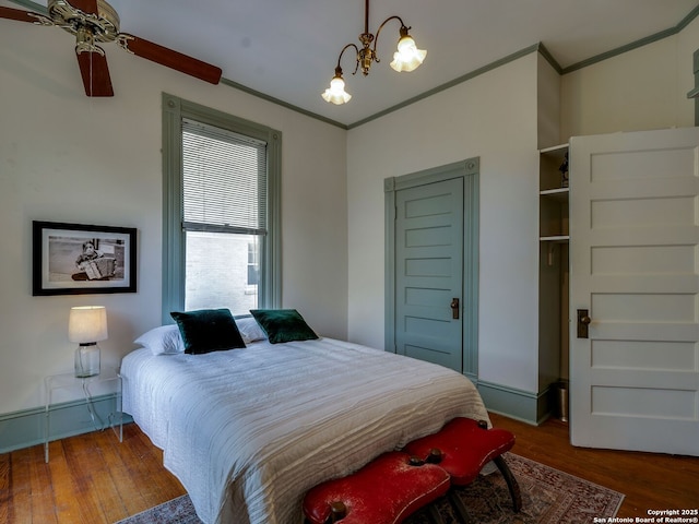 bedroom featuring crown molding, a chandelier, and wood finished floors