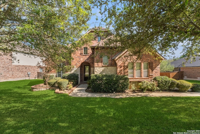 view of front facade with stone siding, a front lawn, and brick siding