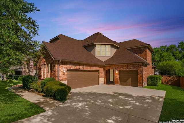 view of front of home featuring brick siding, a yard, and concrete driveway