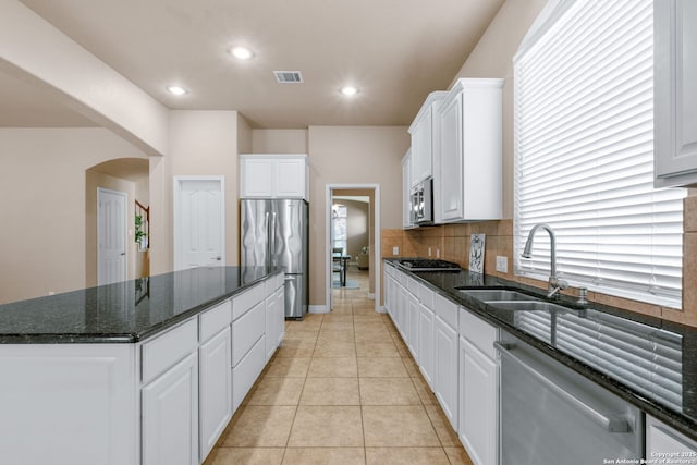 kitchen featuring tasteful backsplash, a center island, visible vents, stainless steel appliances, and a sink