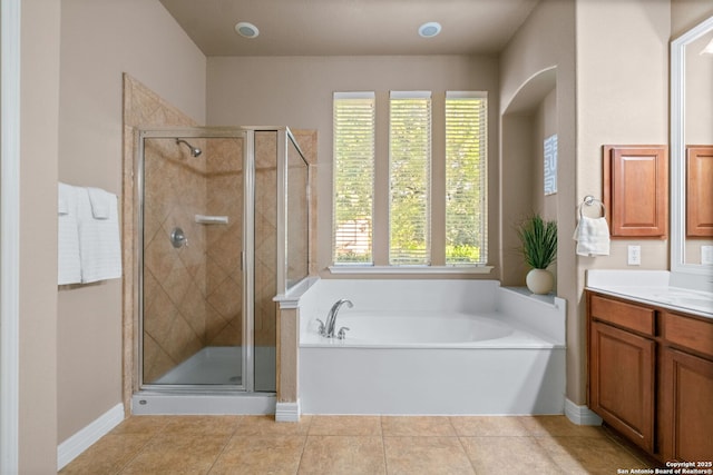 full bathroom with a bath, a stall shower, vanity, and tile patterned flooring