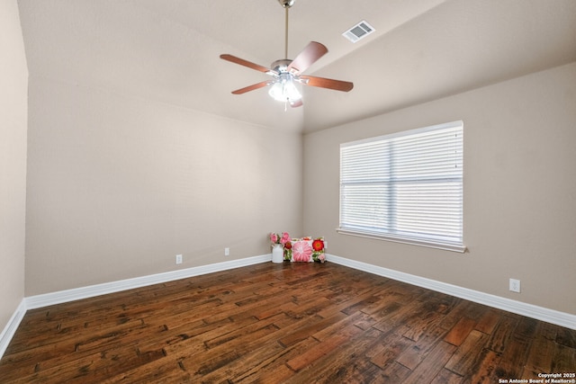 unfurnished room with ceiling fan, dark wood-type flooring, vaulted ceiling, visible vents, and baseboards