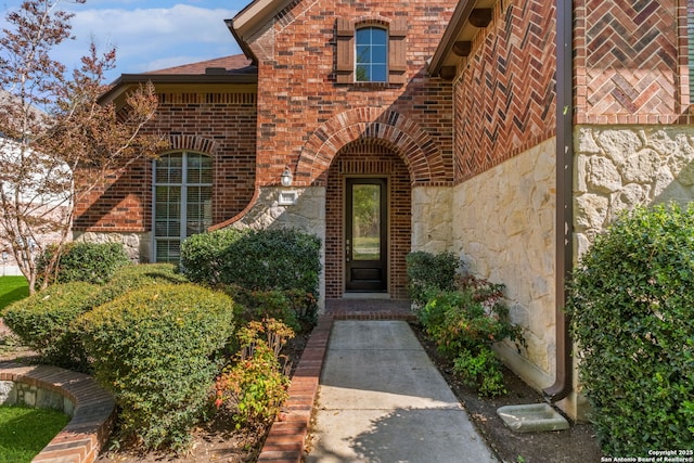 property entrance with brick siding and stone siding