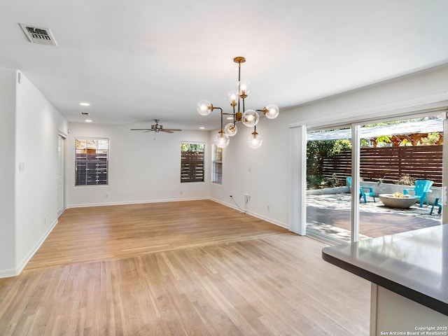 interior space with visible vents, baseboards, light wood-style floors, recessed lighting, and ceiling fan with notable chandelier