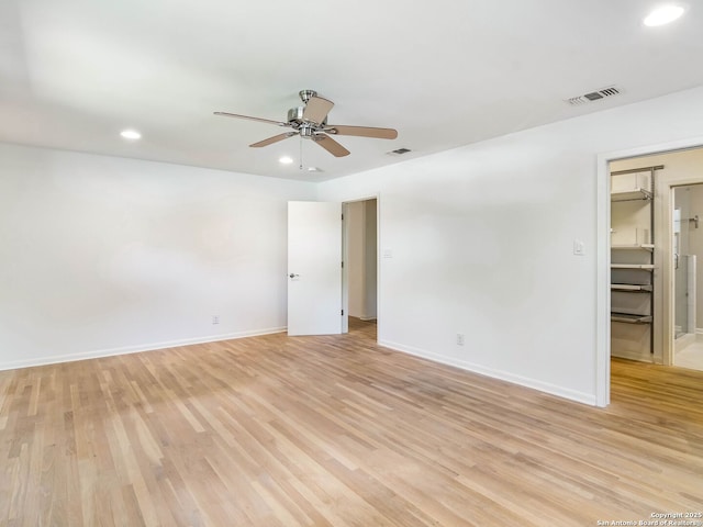 empty room featuring light wood-style floors, recessed lighting, visible vents, and baseboards