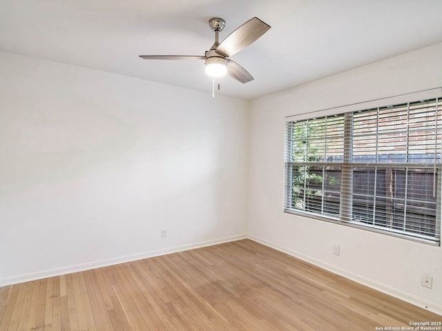 spare room featuring light wood-style flooring, baseboards, and a ceiling fan