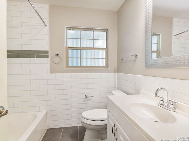 bathroom with vanity, tile patterned floors, toilet, wainscoting, and tile walls