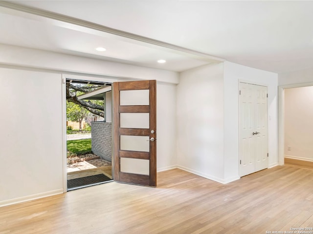 foyer featuring light wood finished floors, baseboards, and recessed lighting